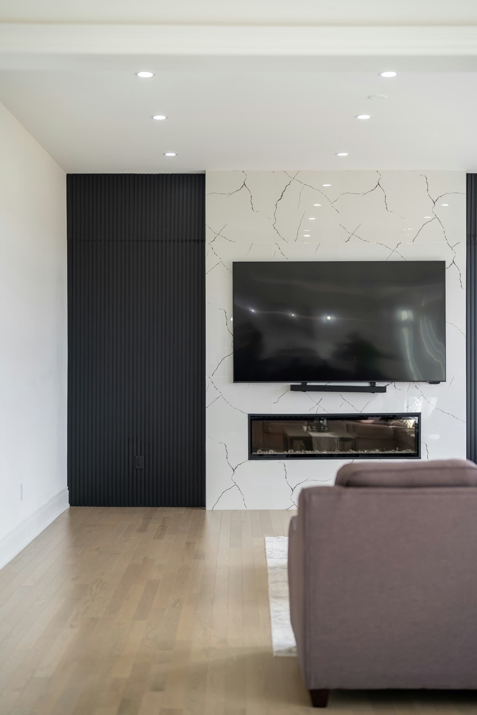 Wall-mounted television above a modern fireplace with a marble-look surround