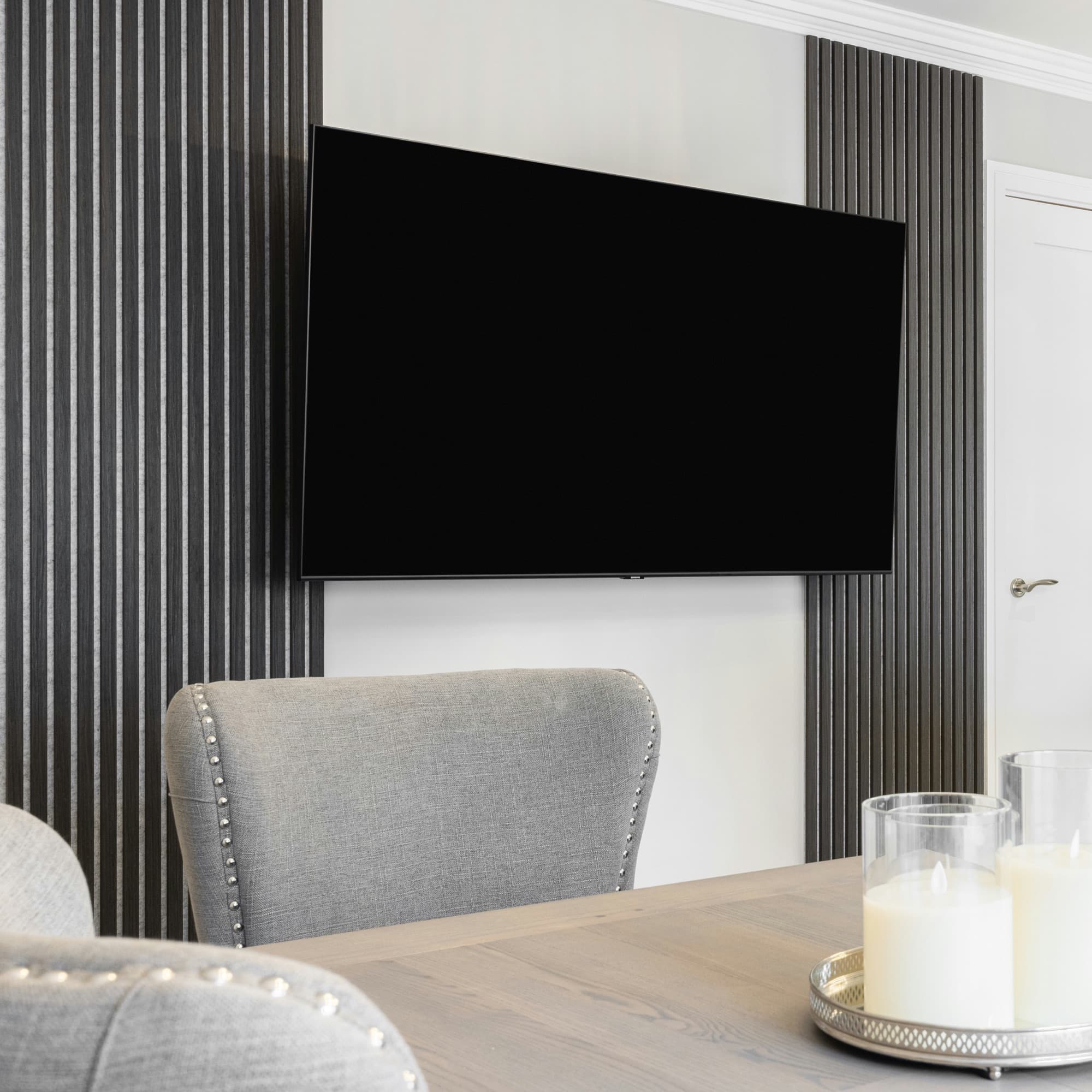 Large television mounted on a finished slat accent wall