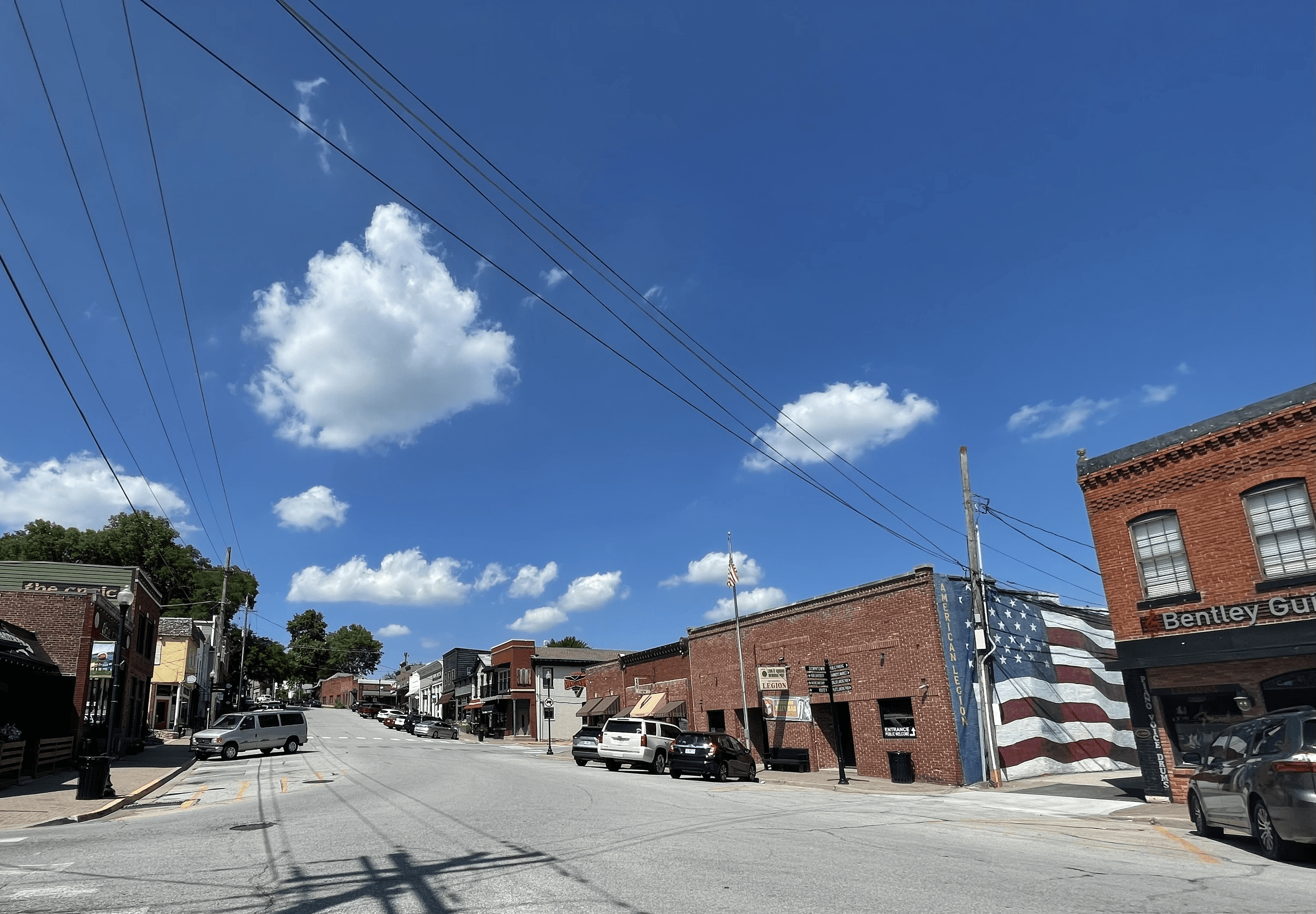 Downtown Parkville street with brick storefronts and a painted American flag mural