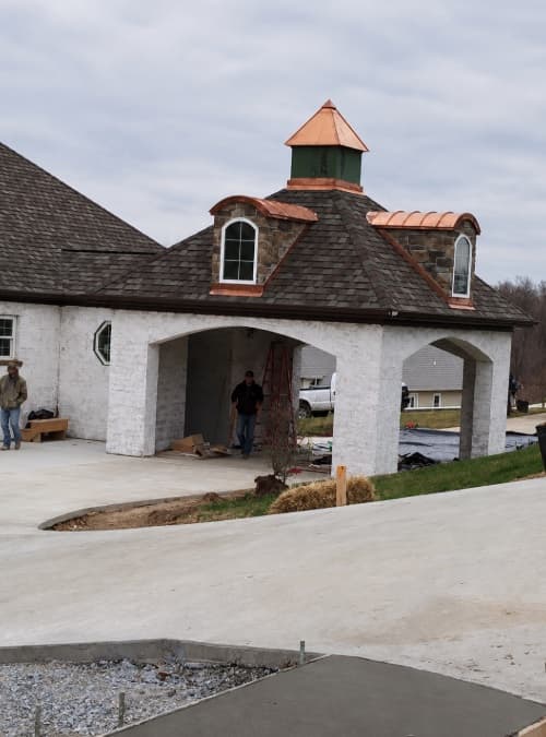 Carriage house exterior with stone dormers and copper roof details