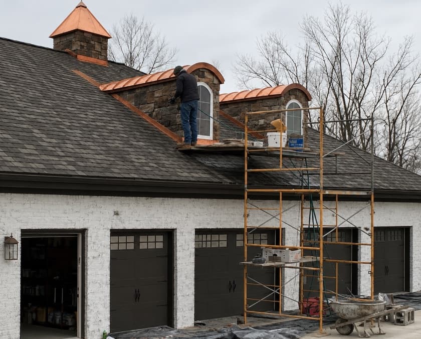 Craftsman completing copper and stone roof detail work
