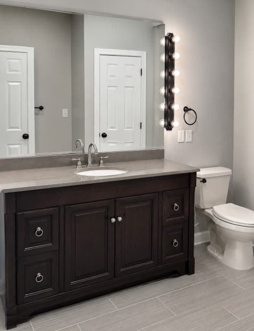 Custom dark wood bathroom vanity and large mirror