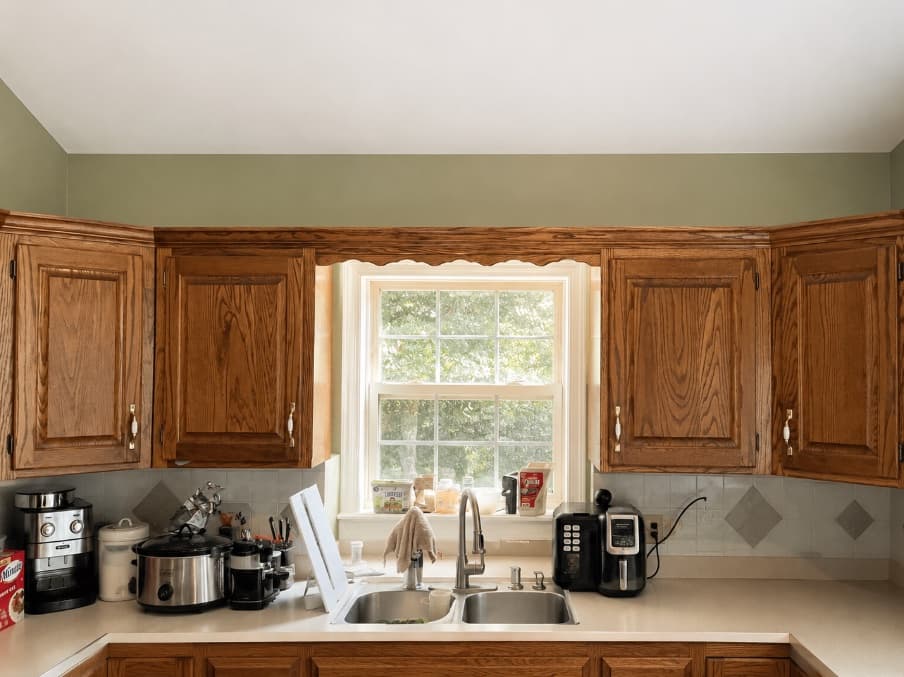 Finished kitchen with wood cabinetry and a bright central window