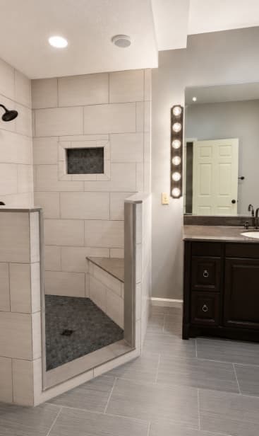 Finished bathroom with a walk-in gray tile shower