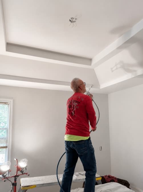 Ken finishing a tray ceiling in a bright room