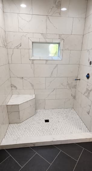 White marble-look walk-in shower with corner seat